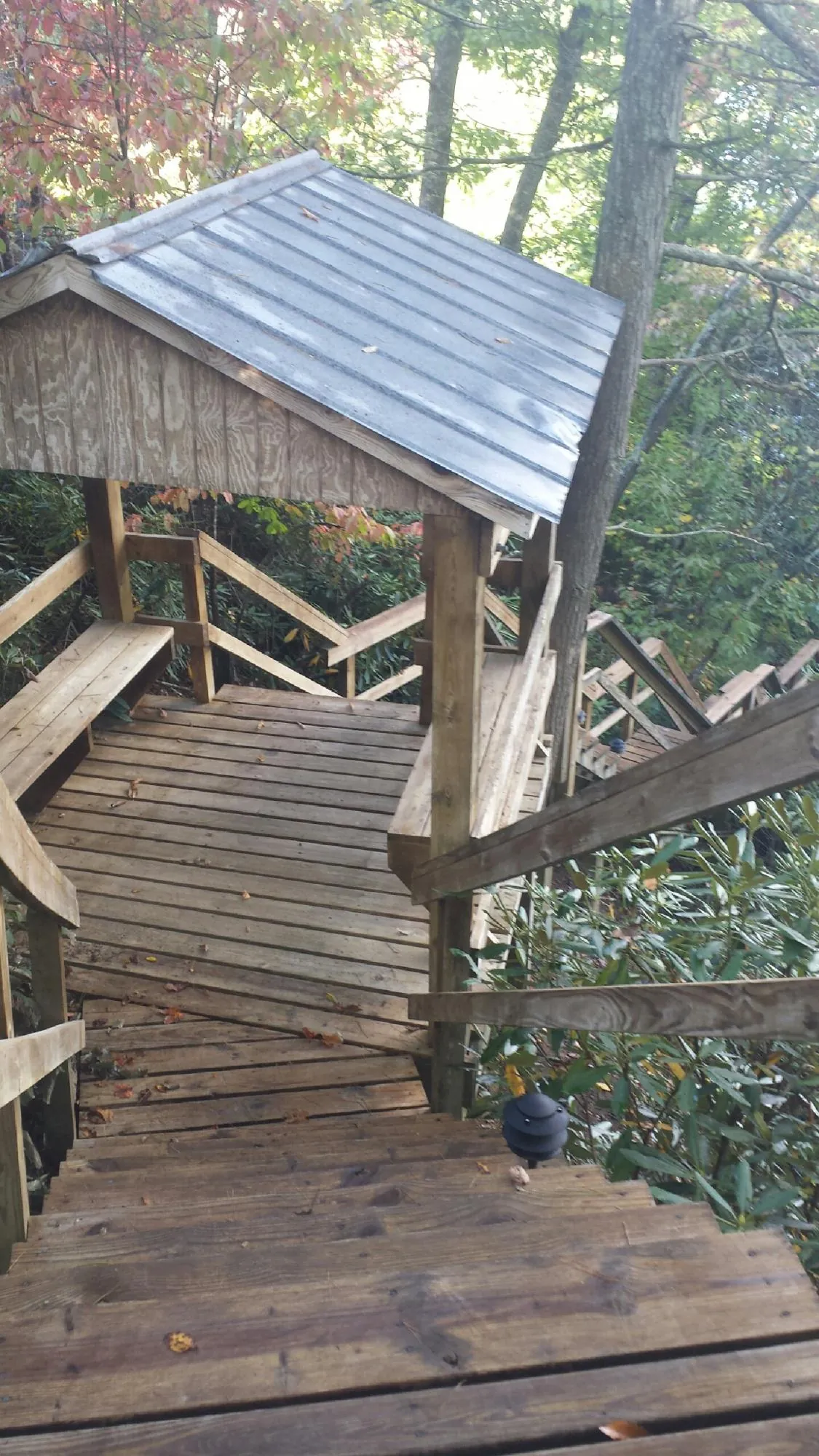 Metal roofed shelter over wooden steps on a wooded walkway — Skylight Repair & Installation work by our crew in Somersworth