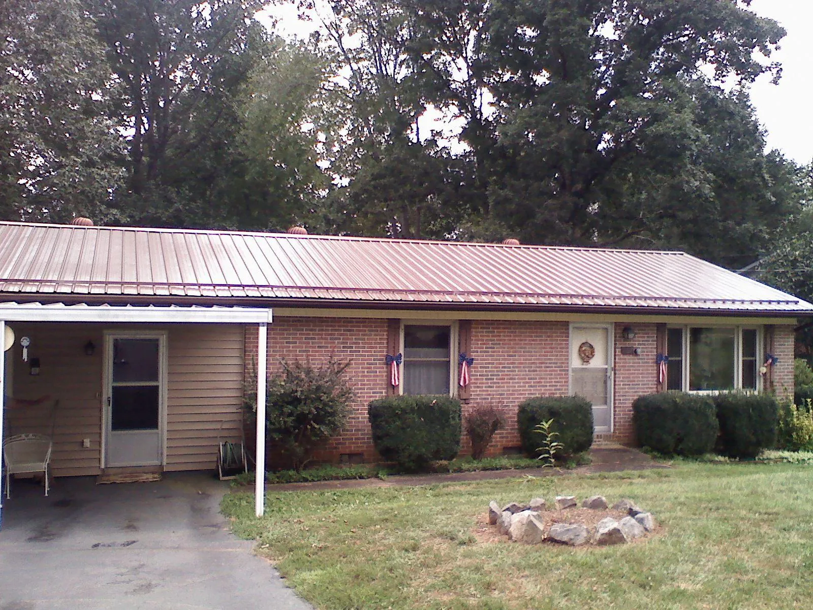 Bronze metal roof and carport on a brick ranch home — Roof Repair work by our crew in Somersworth